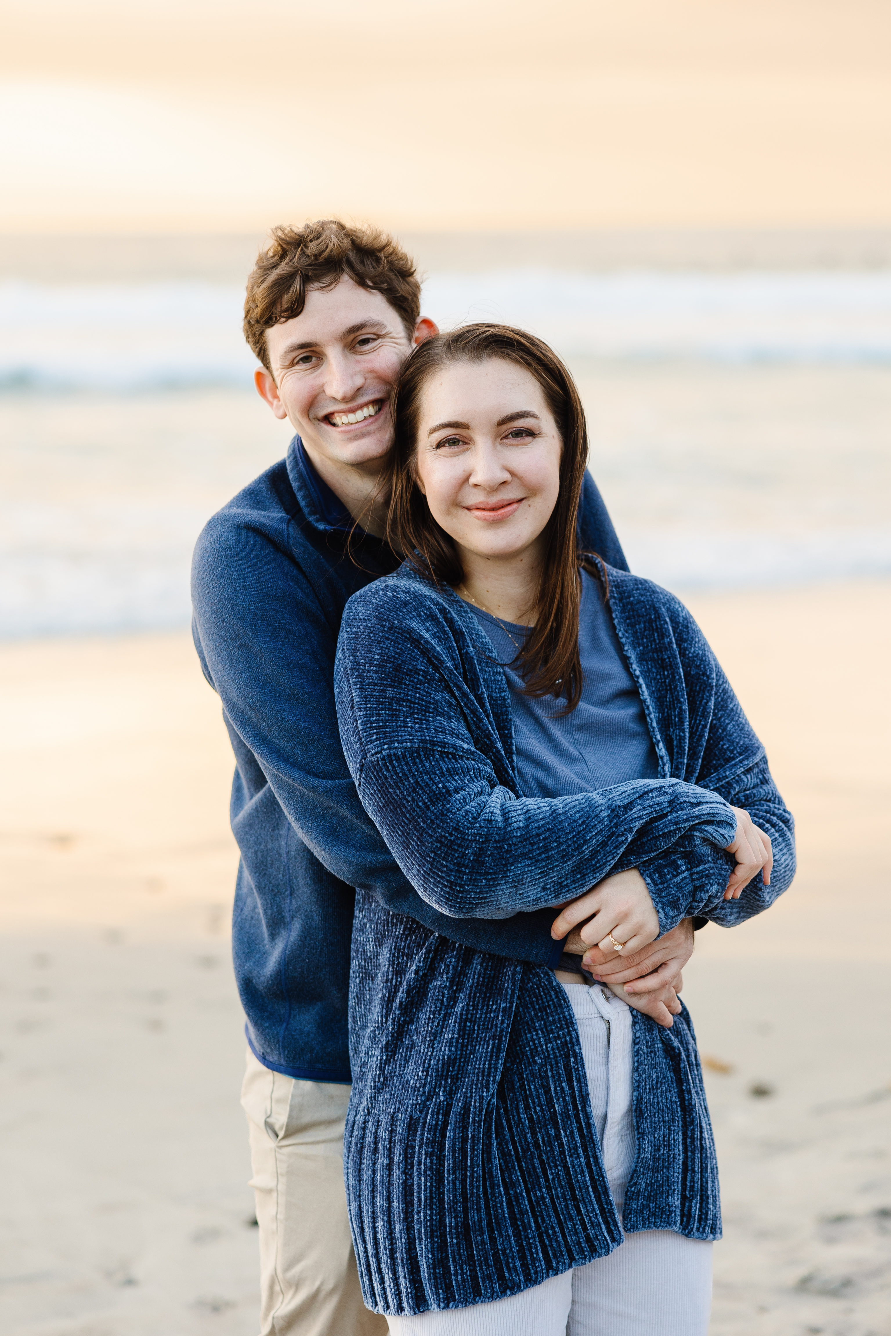 Jenna and Liam embracing on the beach
